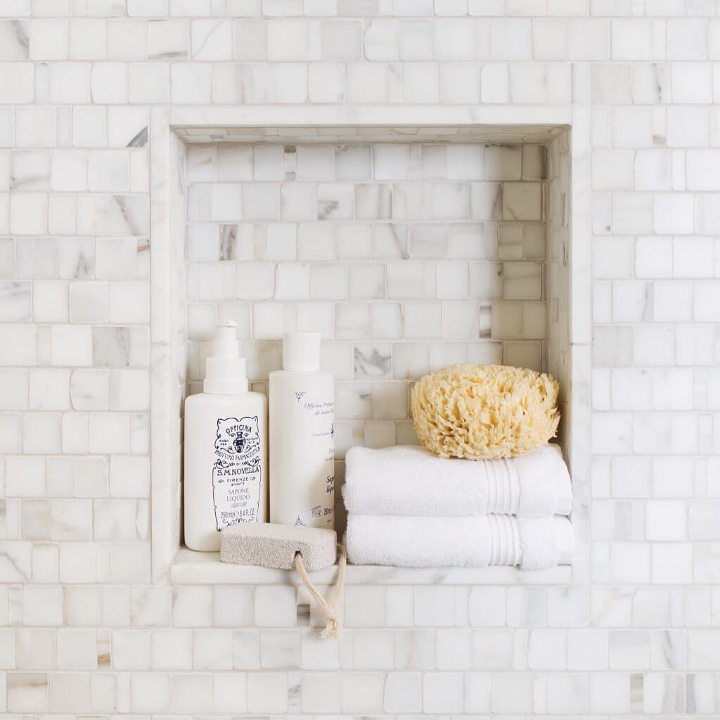 recessed shelf in a shower with soap and towel sitting on it photo by Instagram user @allisondozierinteriors