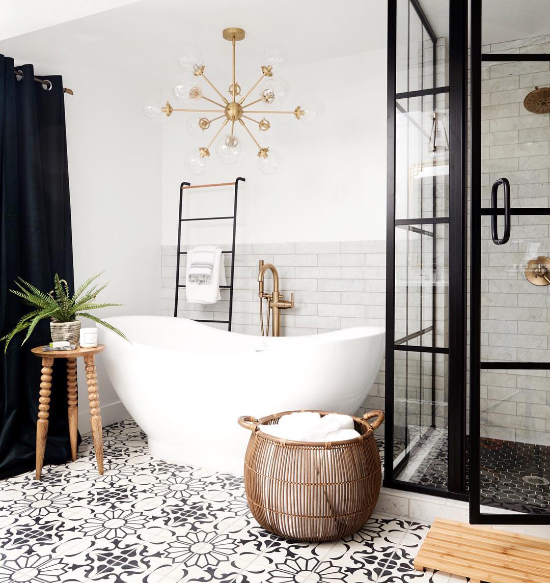 soaking tub in bathroom with chandelier and new tile flooring photo by Instagram user @nicolegerulat