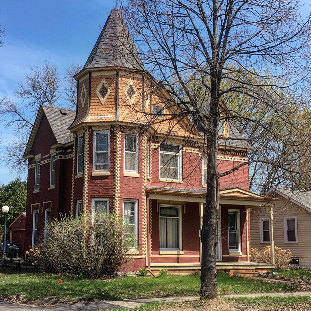 Victorian style home with red brick and yellow siding and trim. Photo by Instagram user @northeastminneapolis