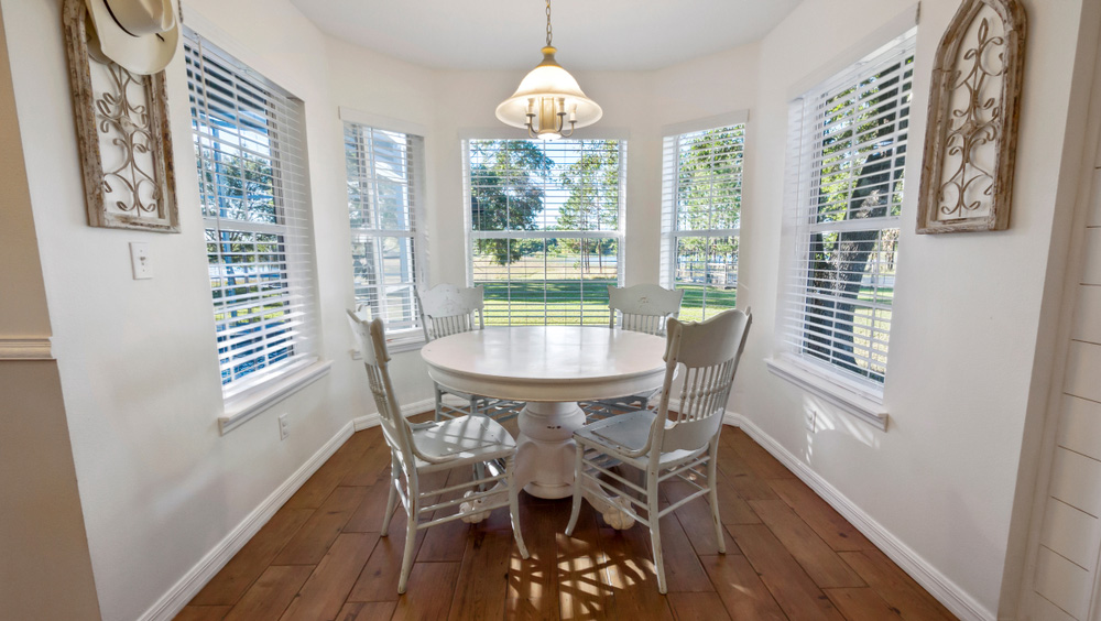 Breakfast nook with round white table in new addition to home.