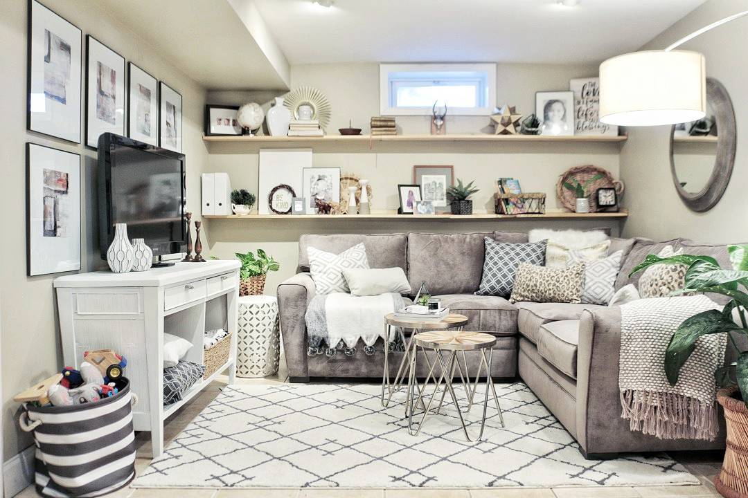 small basement living room with sectional couch and TV photo by Instagram user @madebycarli