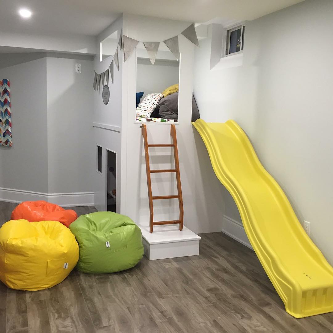 kids play area with yellow slide and bean bags in basement photo by Instagram user @contractingbyus