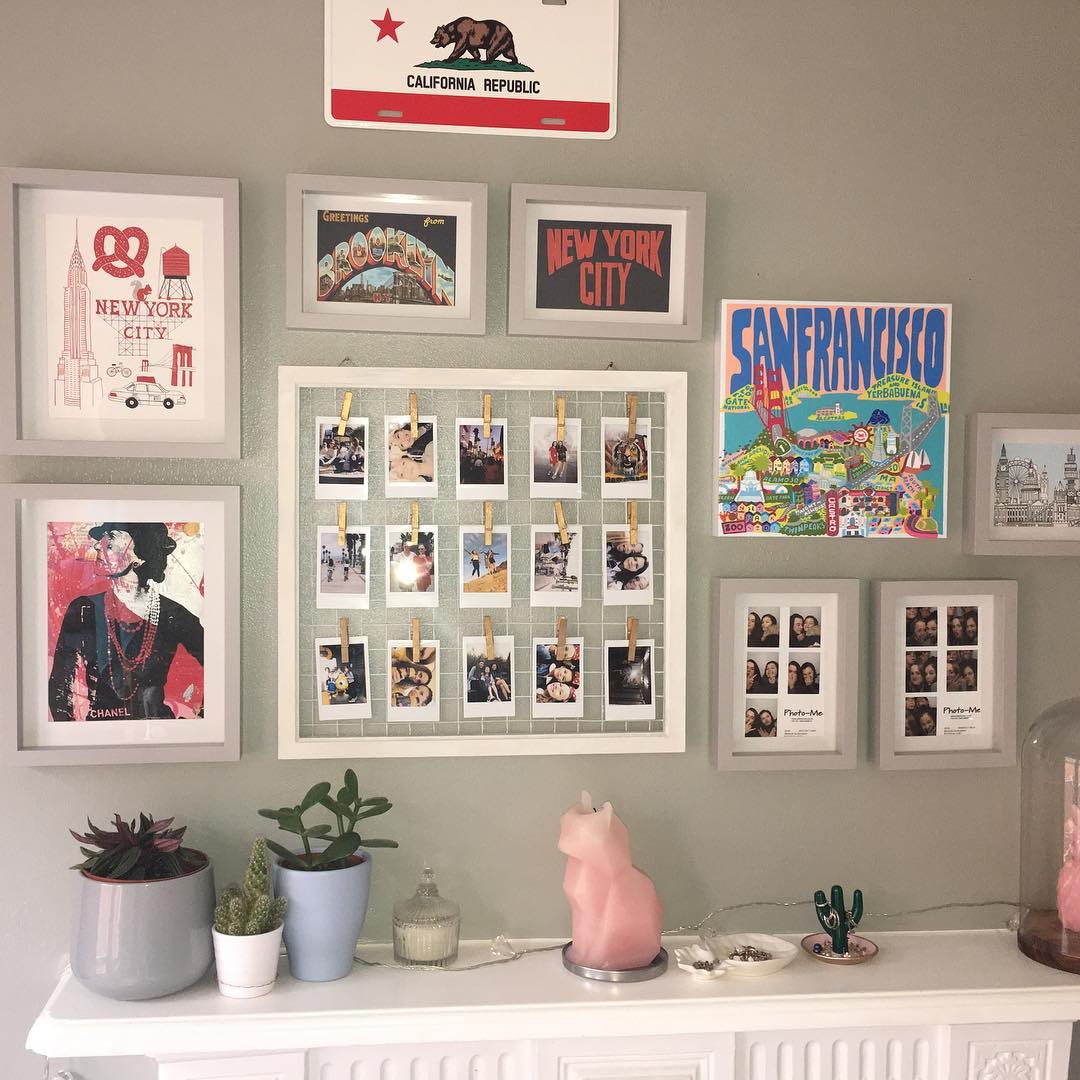 Framed photographs and posters above a bedroom desk.