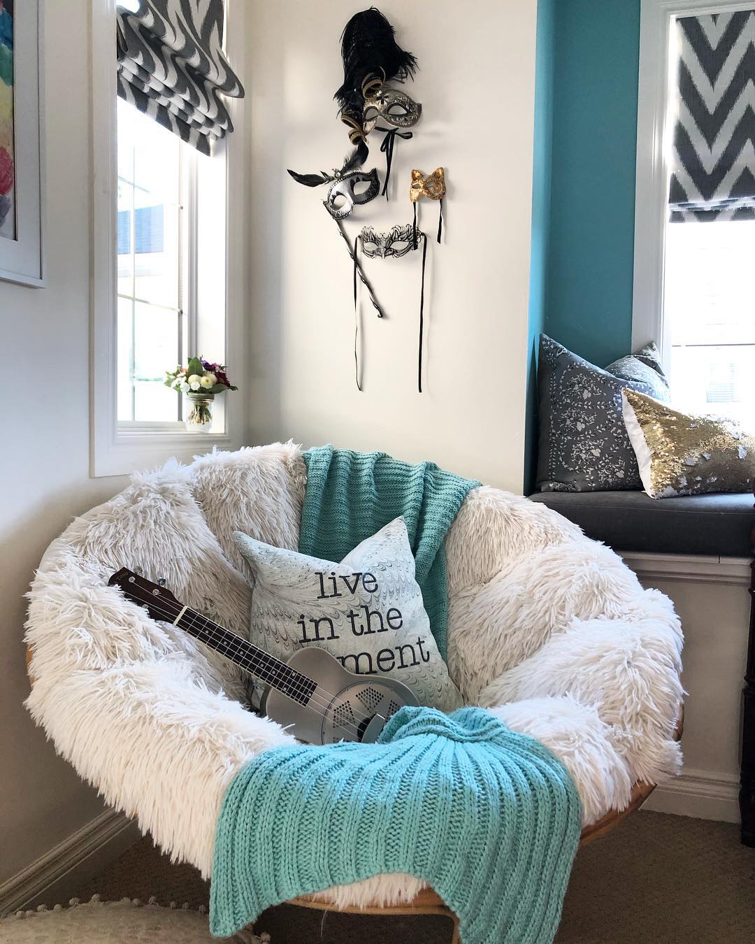 Cozy chair with guitar in bedroom corner.