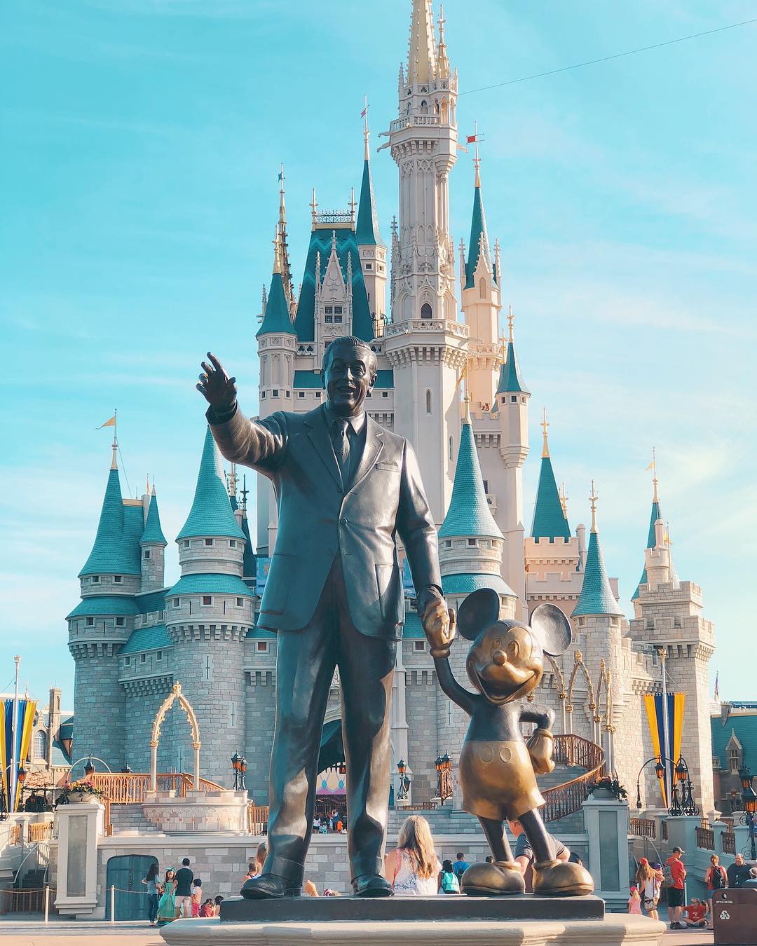 Closeup of statue of Walt Disney holding hands with Mickey Mouse with the Cinderella Castle in the background Photo by Instagram user @wisheseverafter