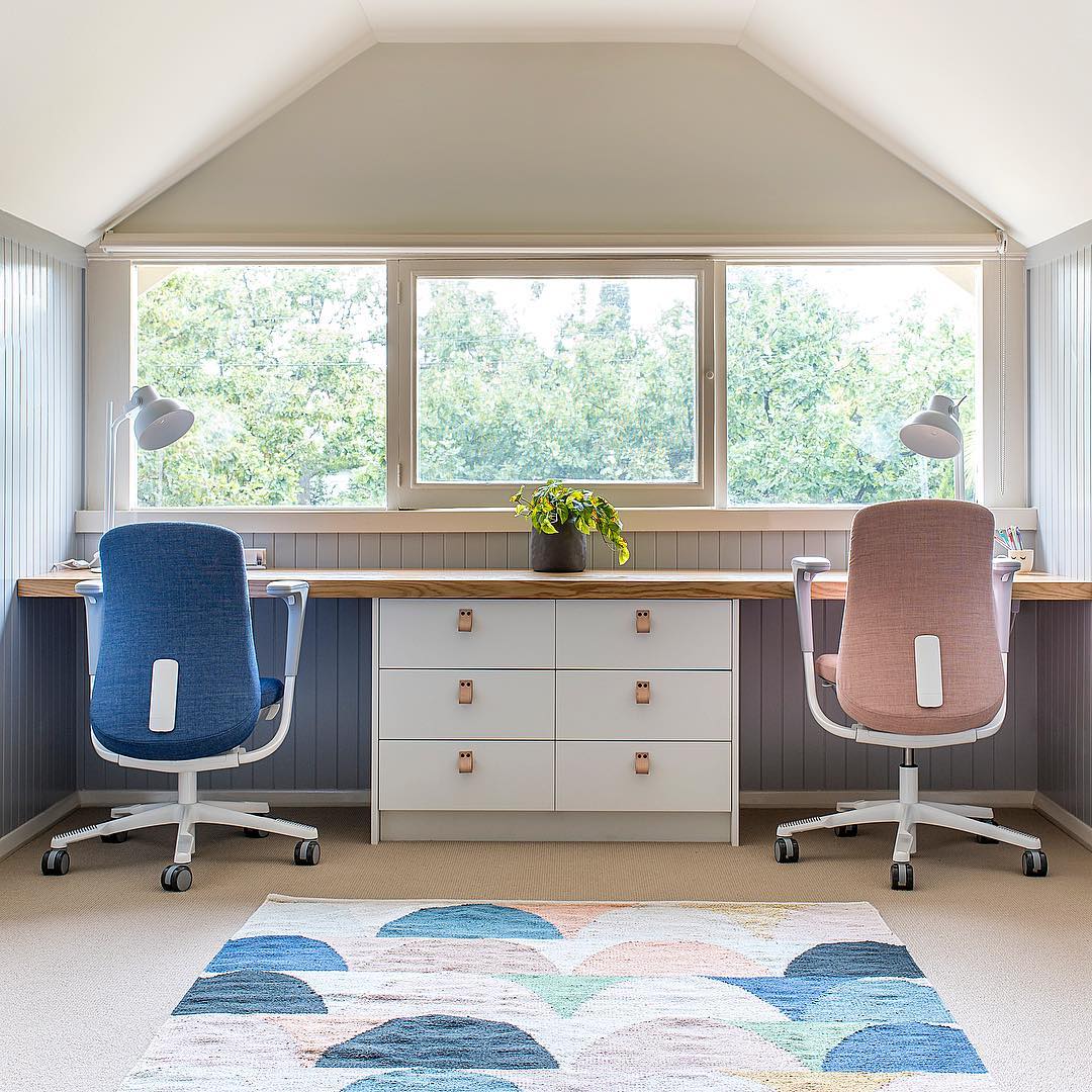 Modern home office with blue and pink color scheme.