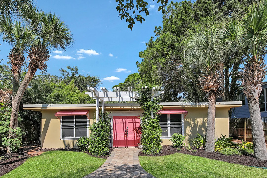 A historic 1950's-style cottage surrounded by palm trees in Tybee Island, Georgia. Photo by Instagram user @ jennyrutherfordrealestate