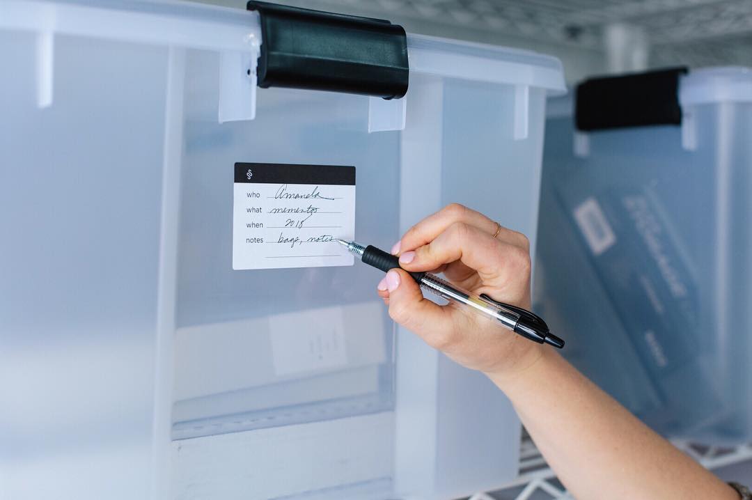 Hand writing on labeled clear bin. Photo by Instagram user @simplyspaced