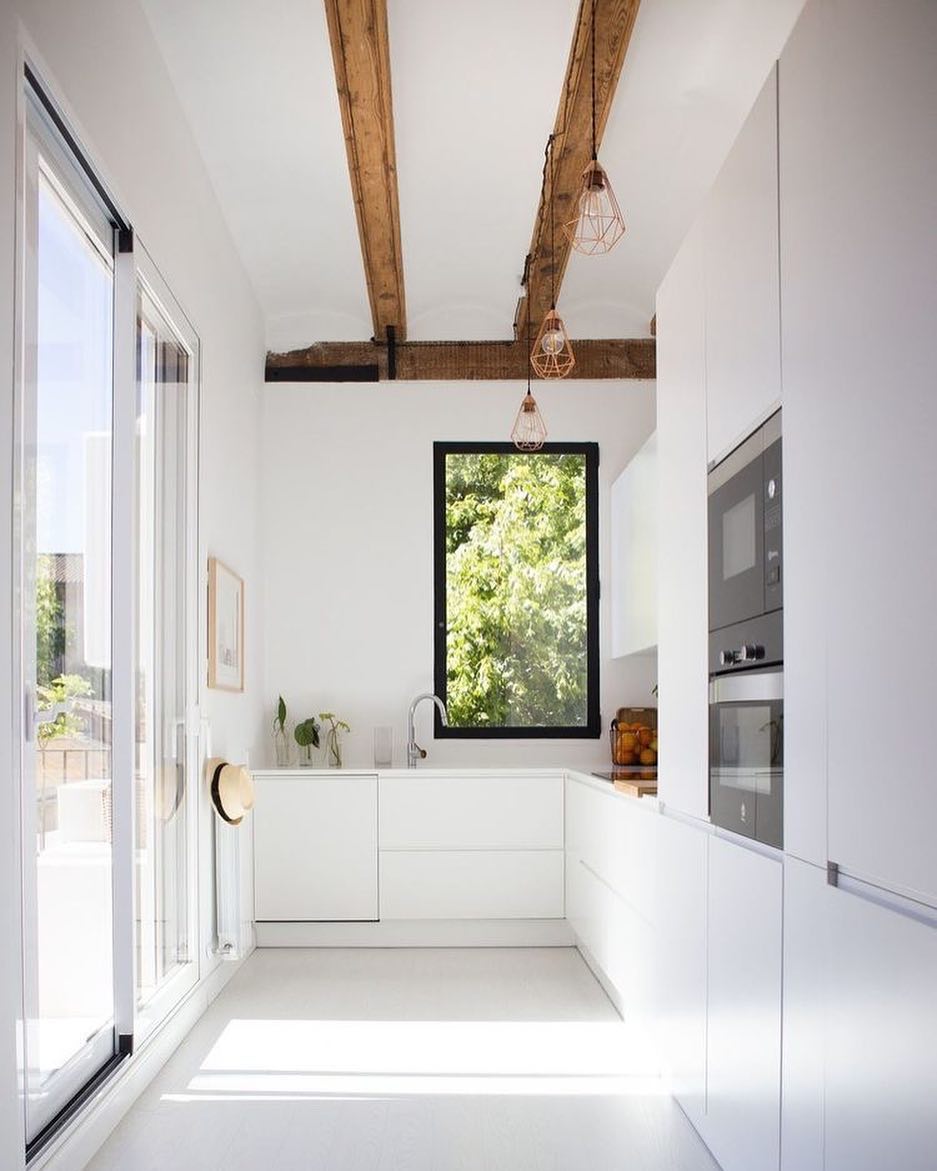 Modern minimalist kitchen with no hardware on doors. Photo by Instagram user @jutrufelliarq