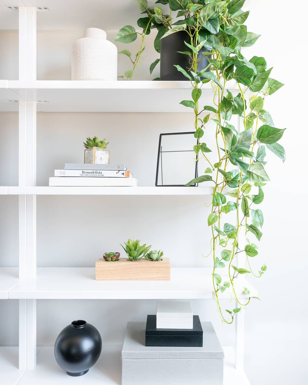 Vertical shelving with minimalist decor. Photo by Instagram user @vivandtim.home