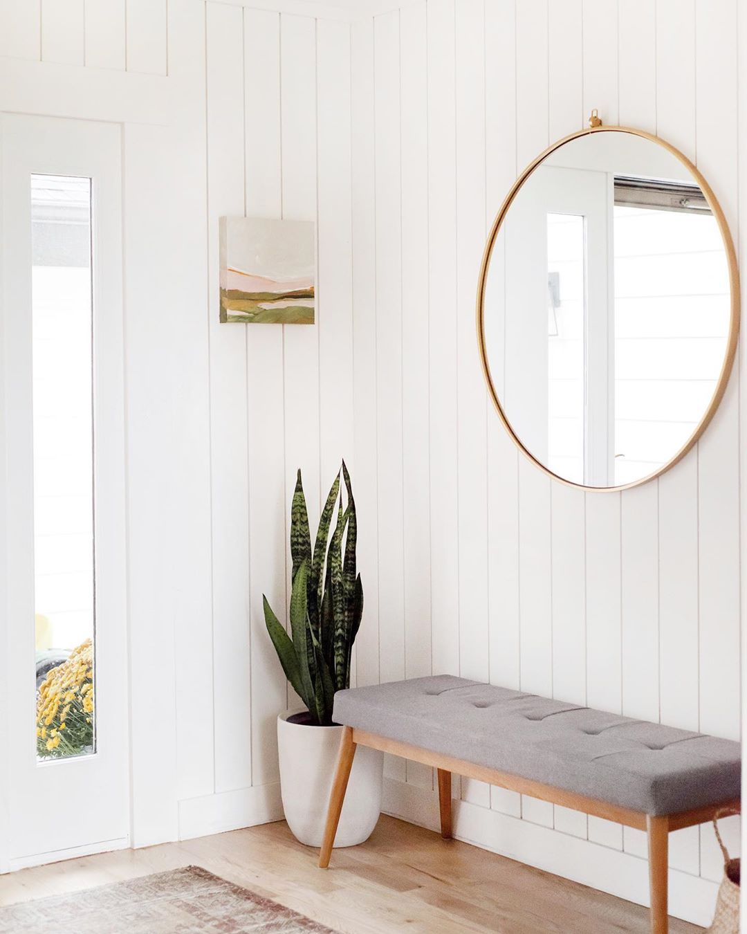 Entryway with shiplap walls and minimalist decor. Photo by Instagram user @kellikroneberger