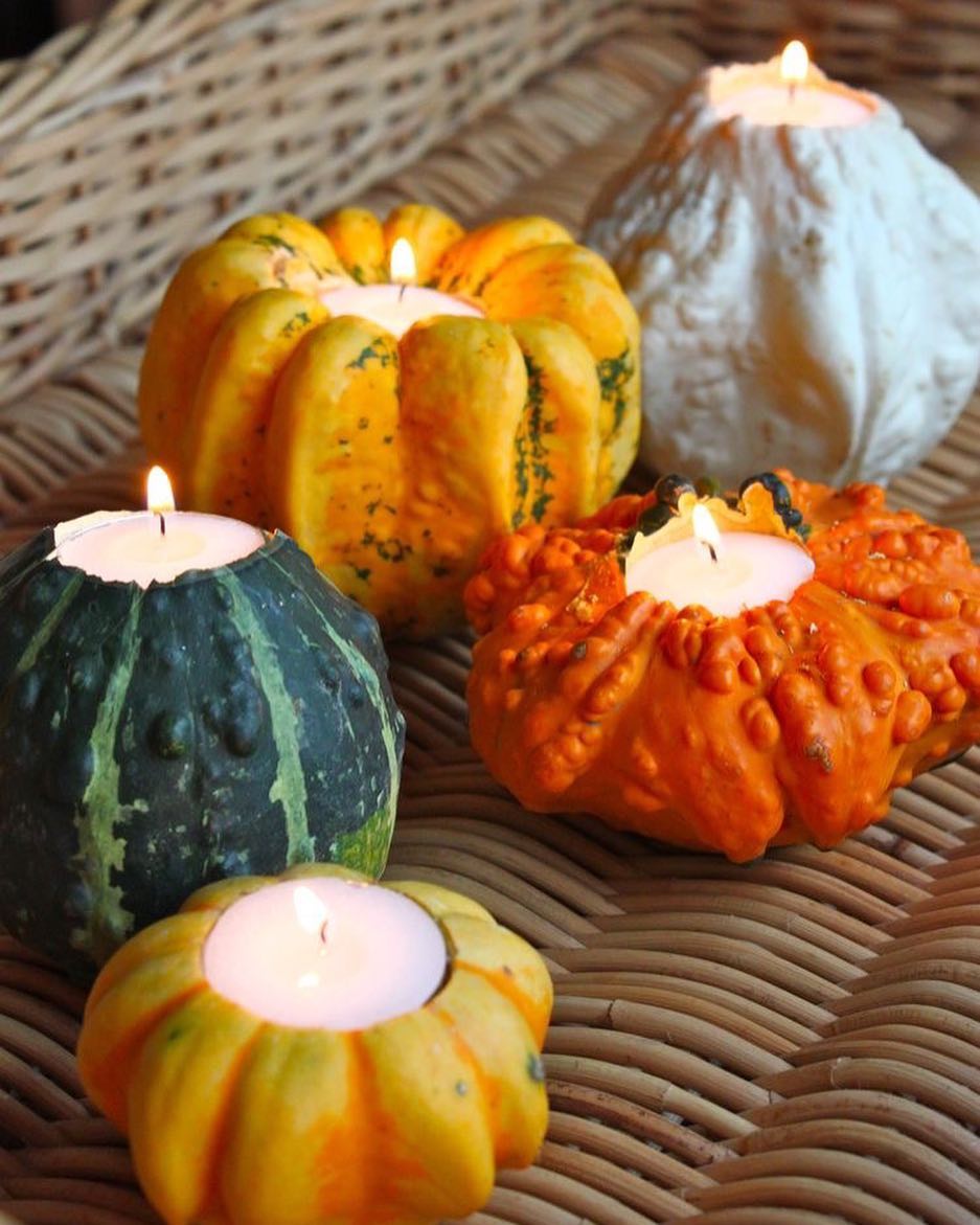 Several Sizes and Colors of Pumpkins Carved Out to be Candle Holders. Photo by Instagram user @theartofsimple