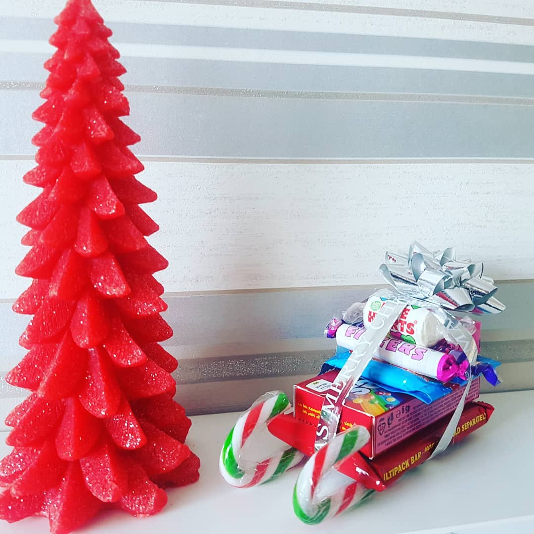 Boxes of Candy Stacked on Top of Candy Canes to Resemble a Sleigh as a Gift. Photo by Instagram user @prettylittlegiftsshop