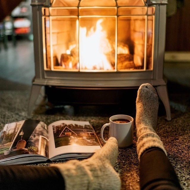 Person Relaxing with a Magazine and Hot Cocoa in Front of a Detached Fireplace. Photo by Instagram user @vanessa_hinds