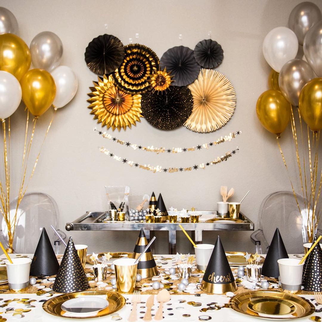 Gold and Black Sparkly Hats, Plates, and Other Decorations for New Years Eve Party. Photo by Instagram user @toteshost