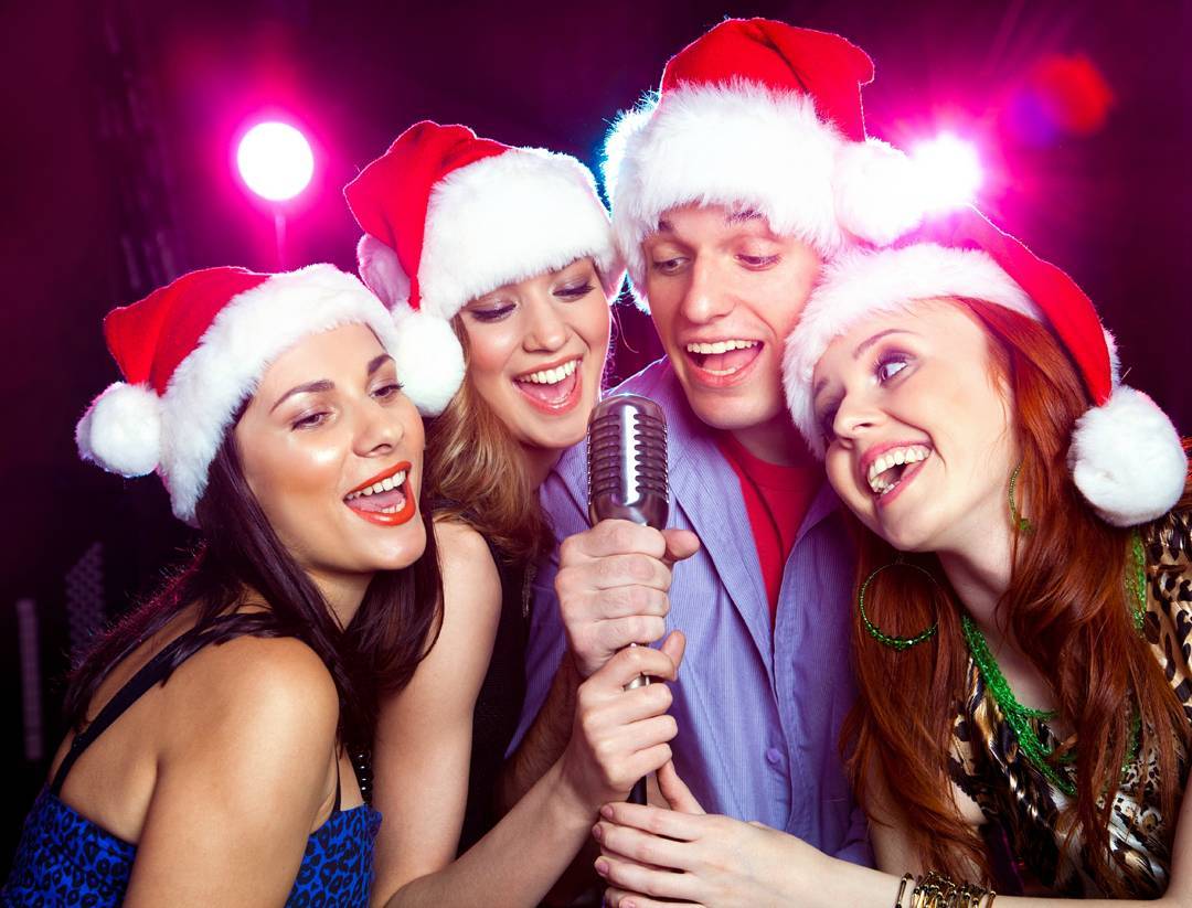 People Wearing Santa Hats and Singing Karaoke Into a Microphone. Photo by Instagram user @barhisamladih
