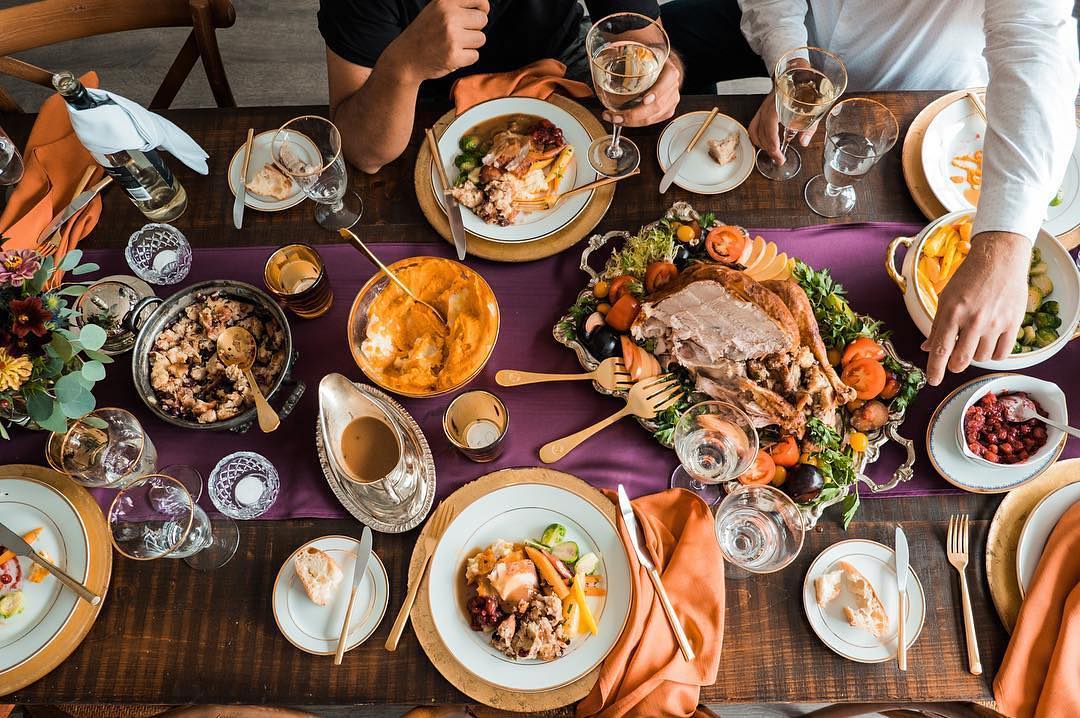 Dinner Table Full of Plates with Thanksgiving Turkey Dinner. Photo by Instagram user @chairmanmills