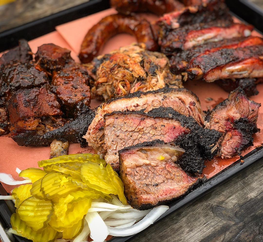 Tray of various barbequed meats and fresh pickles Photo by Instagram user @bbqpit.de