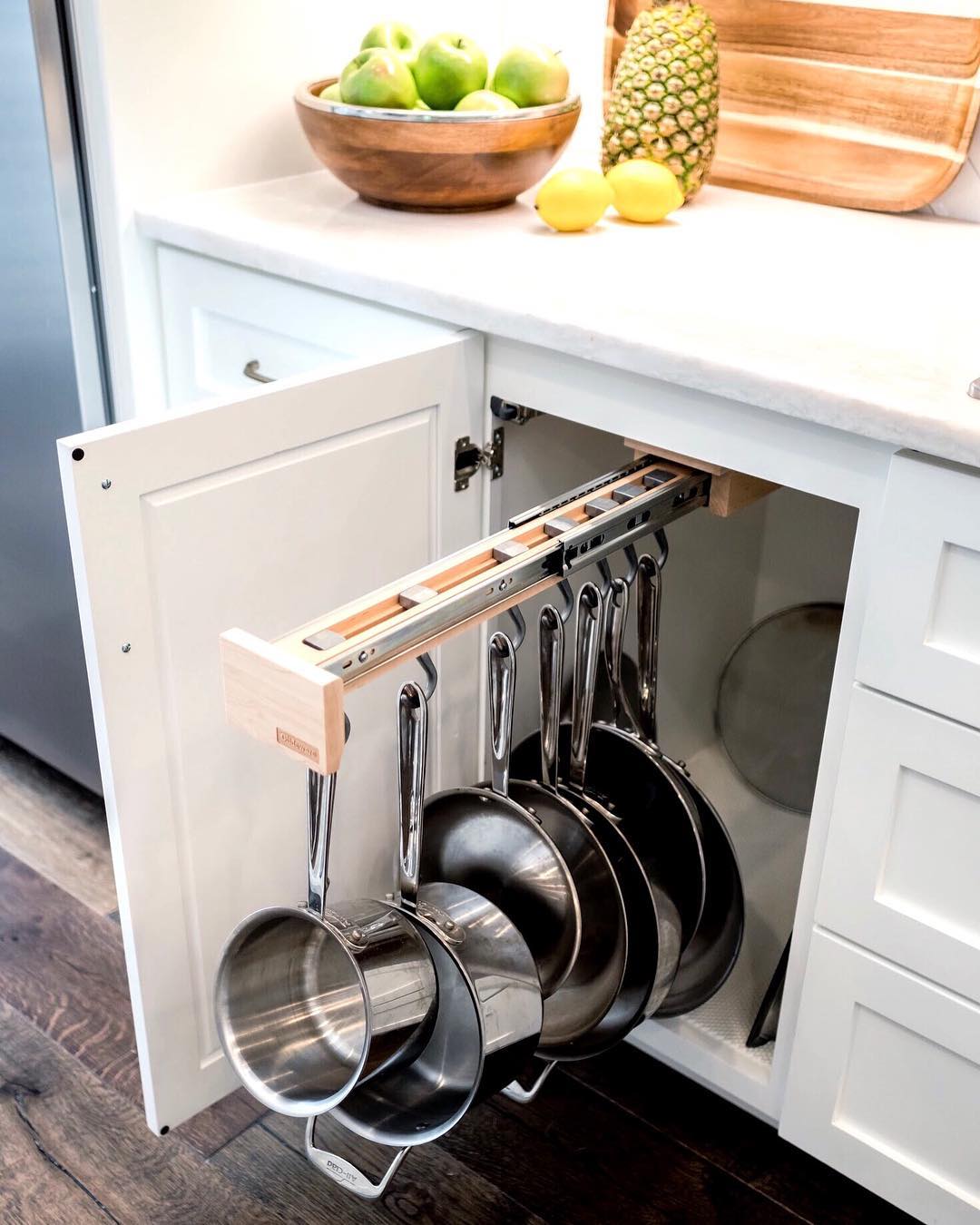 Slide-out pots and pans organizer in cabinet. Photo by Instagram user @designdirectionsokc