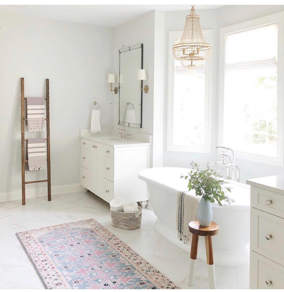 Clean white bathroom with gold accents. Photo by Instagram user @joneshollowcontracting