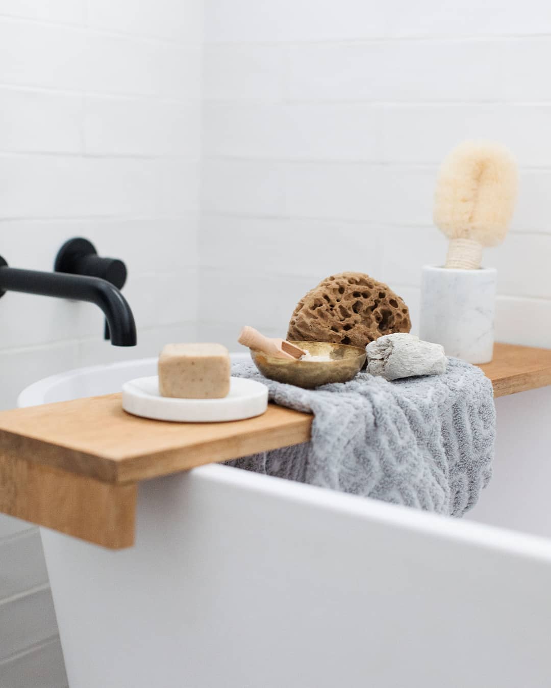 Bathtub shelf with loofas and sponges. Photo by Instagram user @stylecuratorau