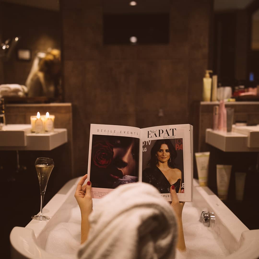 Woman reading magazine in bathtub. Photo by Instagram user @bella_zofia