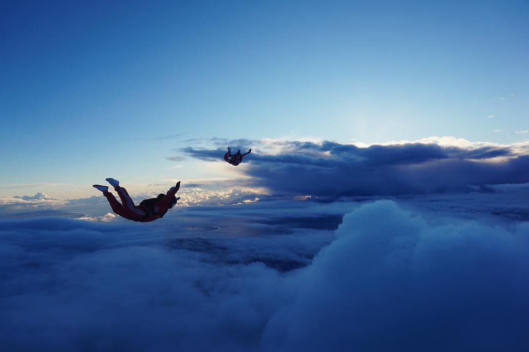 Couple Skydiving Above the Clouds. Photo by Instagram user @floorgaasbeek