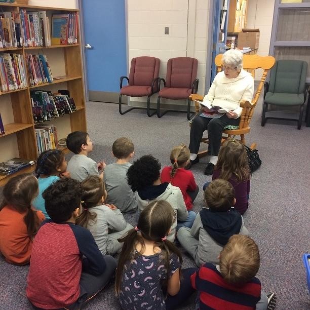 Elderly Woman Reading to Elementary Students. Photo by Instagram user @allseniorscarelivingcentres