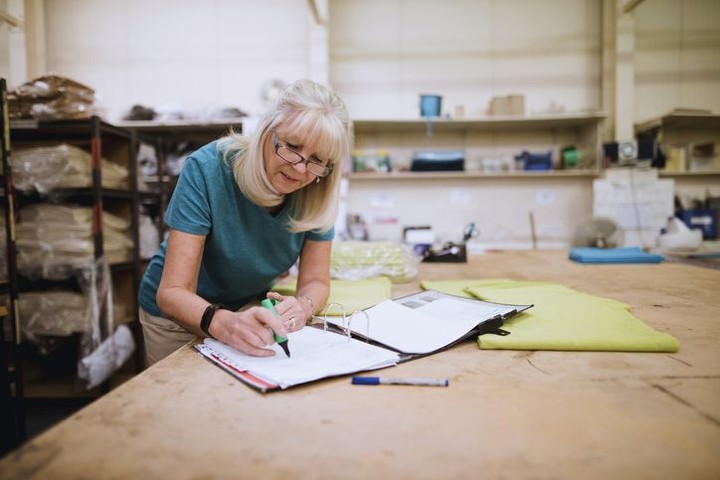 Woman Writing in Notebook in Storeroom. Photo by Instagram user @naswsocialworkers