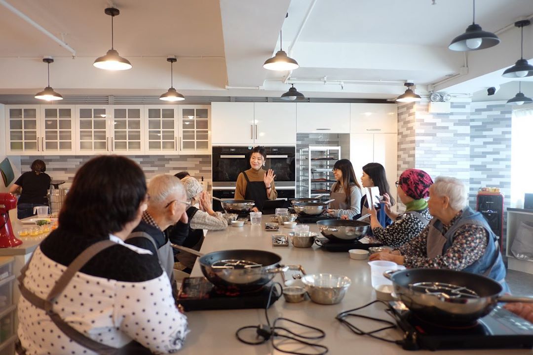 Group of Elderly Men & Women Taking a Cooking Class. Photo by Instagram user @cookingemem