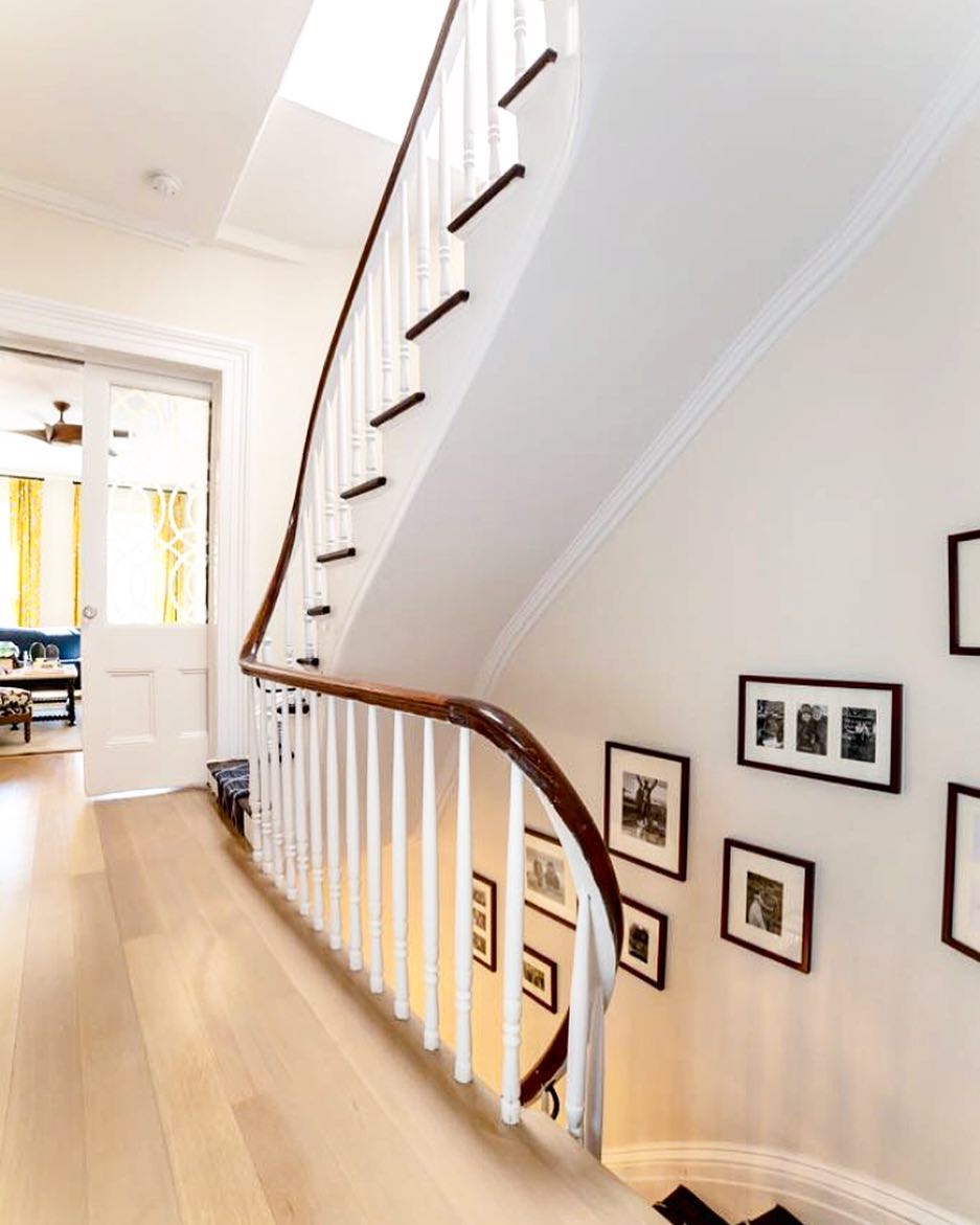 Stairwell with personal photos on wall. Photo by Instagram user @marieburgos.design