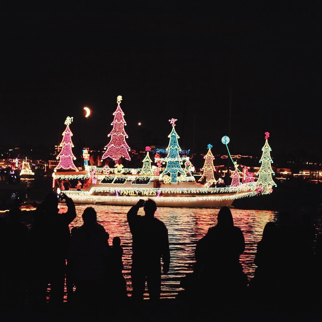 Boat lit up with Christmas lights in the water. Photo by Instagram user @visitnewportbeach