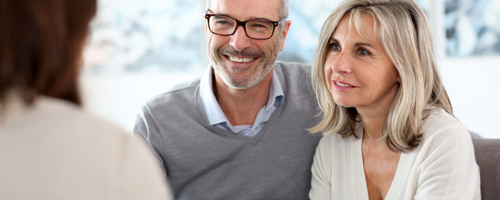 Middle aged white woman and man speaking with accountant.