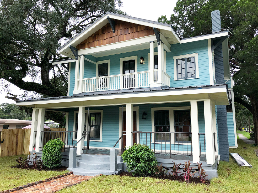 Two story blue home with white trim and a intimate front porch and baclony on second level. Photo by Instagram user @seminoleheightshomes