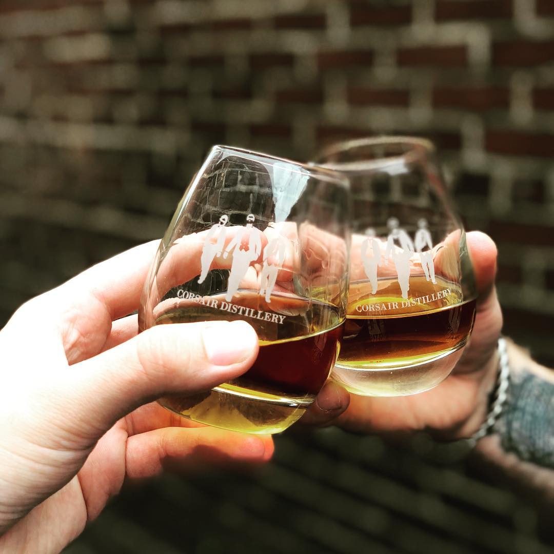 People Cheer'sing Glasses at the Corsair Distillery. Photo by Instagram user @corsairdistillery