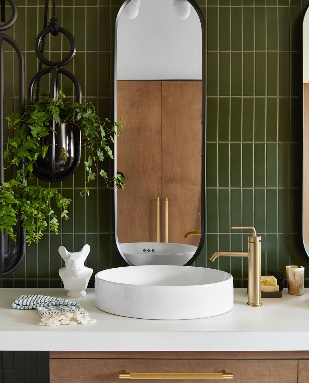 Bathroom vanity with green tile backsplash. Photo by Instagram user @fireclaytile