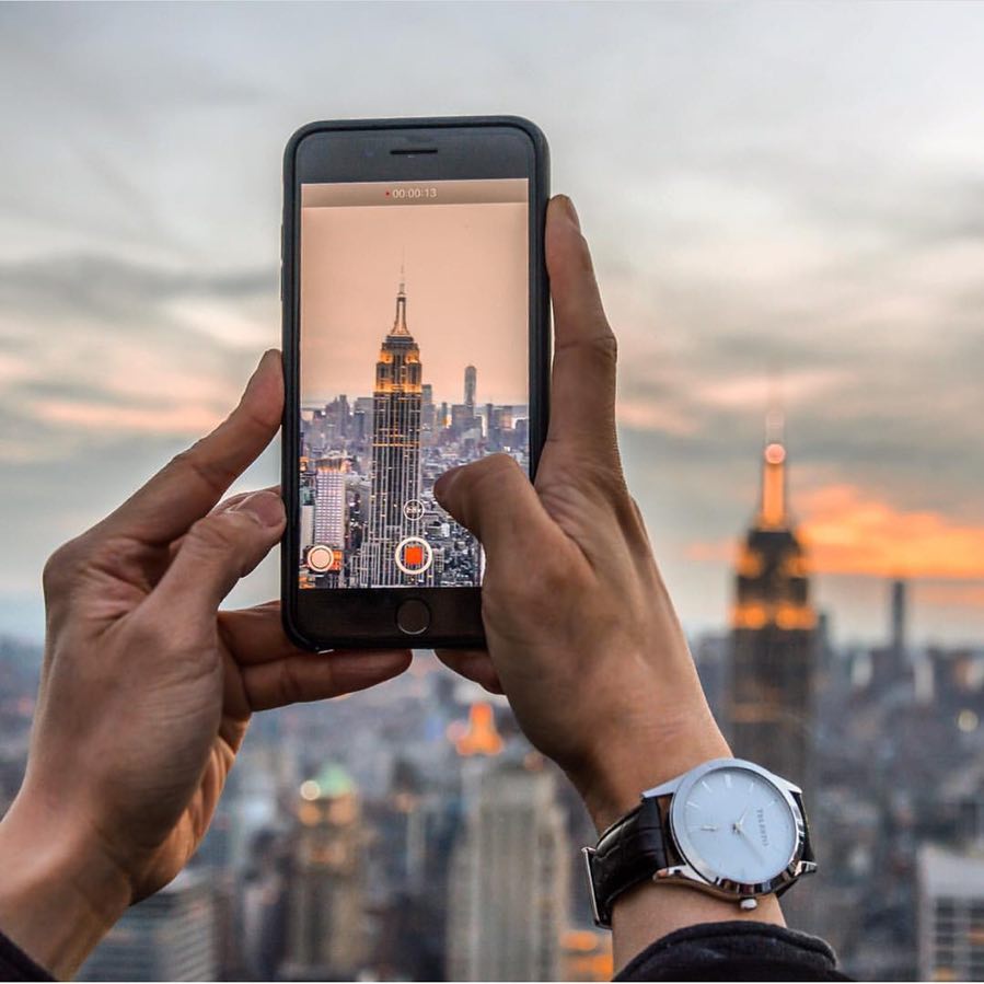 Man Using His Phone to Take a Photo of the Empire State Building. Photo by Instagram user @telestowatches