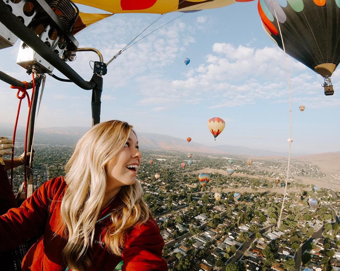 Thrilled Woman Riding in a Hot Air Balloon High Above the Ground. Photo by Instagram user @ashploussard