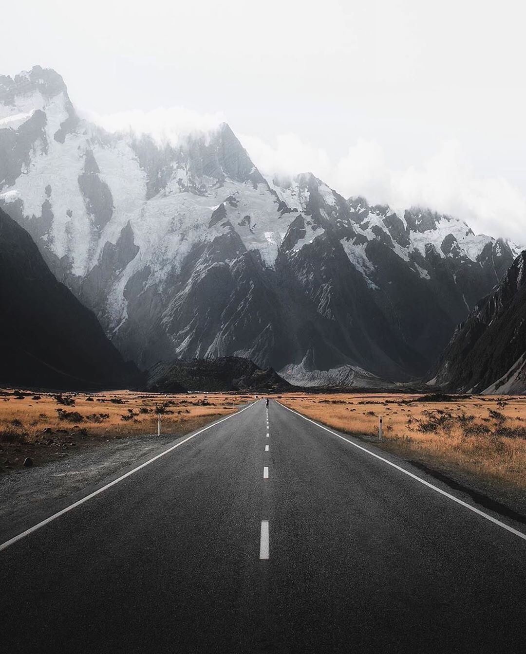Open Road in Front of a Mountain Range. Photo by Instagram user @earth.all