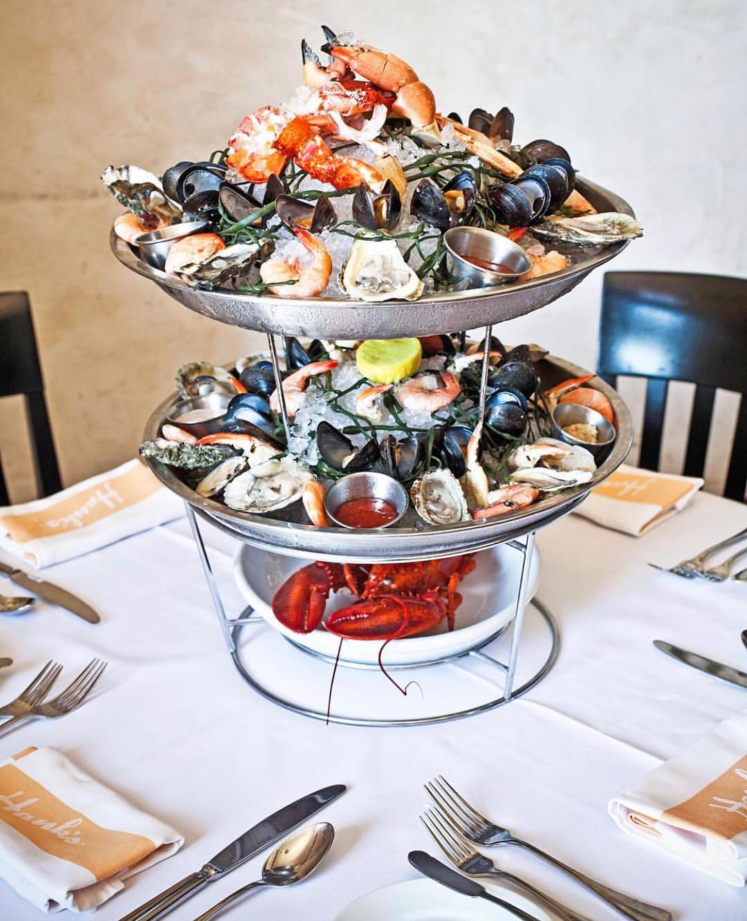 Multiple types of seafood piles on a multi-tiered serving tray. Photo by Instagram user @hanksseafood