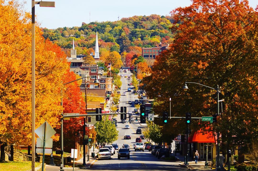 Fall colored trees line main street in Fayatteville, AR photo by Instagram user @fayettevillear