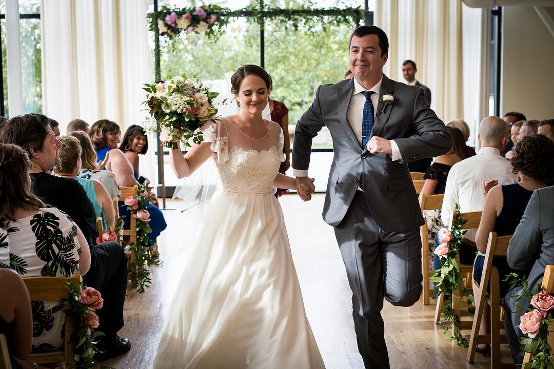 Bride and Groom Dancing Down the Aisle in Chicago's Greenhouse Loft. Photo by Instagram user @jamieandericphoto