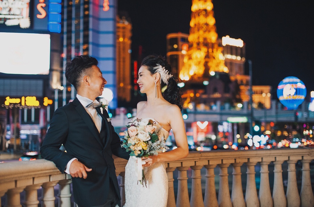 Bride and Groom Smiling at Each Other on the Las Vegas Strip. Photo by Instagram user @hazukiphotography