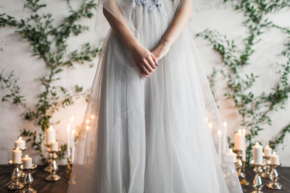 Bride with hands clasped standing at altar