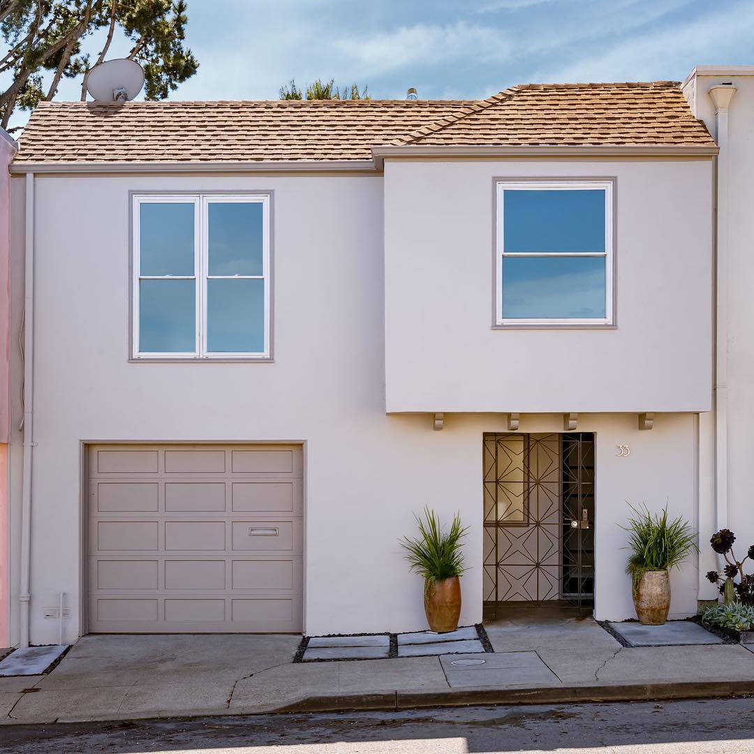Front view of a light pink vista with gated front door and single car garage. Photo by Instagram user @vanguardproperties