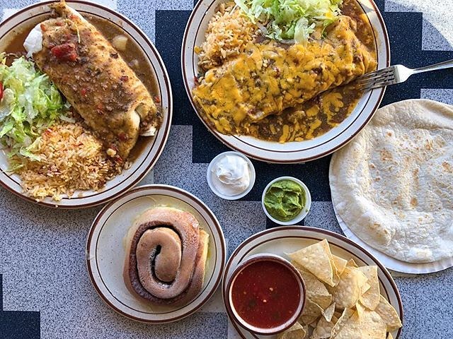 Overhead view of a large meal with burritos, cinnamon rolls, tortilla chips and tortillas. Photo by Instagram user @visitabq