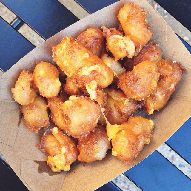 Closeup of fried cheese curds in a paper bowl. Photo by Instagram user @justminspired