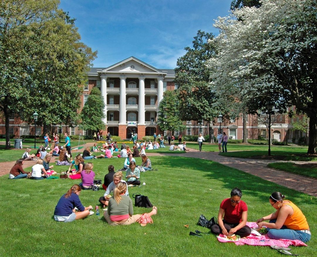 The William Peace University campus featuring several students socializing on the lawn. Photo by Instagram user @wpeaceu.