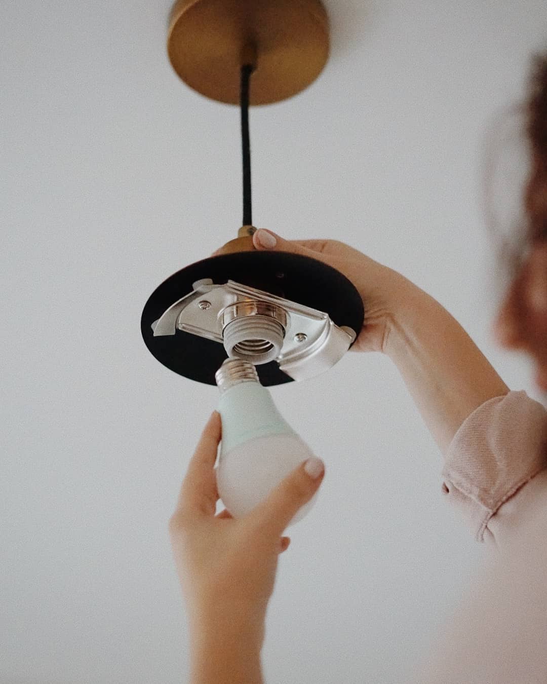 Woman changing light bulb. Photo by Instagram user @soraahome