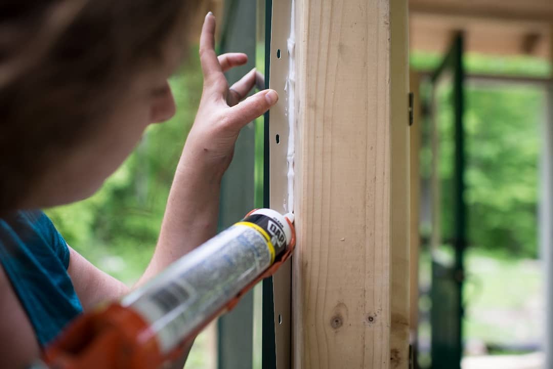 Woman adding caulk to wooden panel in home. Photo by Instagram user @gharpedia